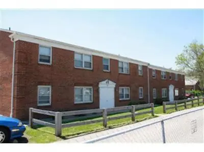 a brick building with a fence in front of it at 17 S First - Unit 6 17 s first street unit 6 in Trenton