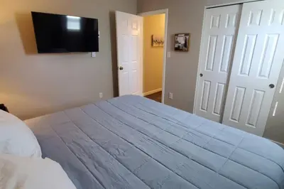 a bedroom with a large bed and a flat screen tv at 219 Maxwell St Unit B Such a great place to work and stay in Franklin