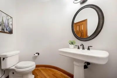 a bathroom with a toilet and a sink and a mirror at 5755 Butler Warren Cheerful 6-Bedroom Villa with fishing pond in Jericho