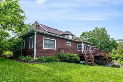a house with a deck on a lawn at 5755 Butler Warren Cheerful 6-Bedroom Villa with fishing pond in Jericho