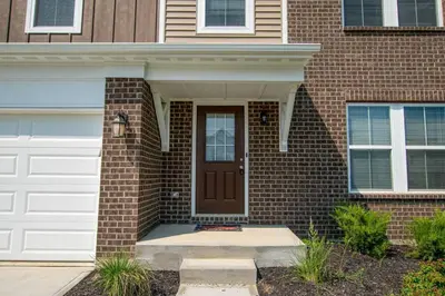 a brick house with a brown door and a white garage at 1392 Soaring Way Brand new construction in well-kept HOA community in Maineville