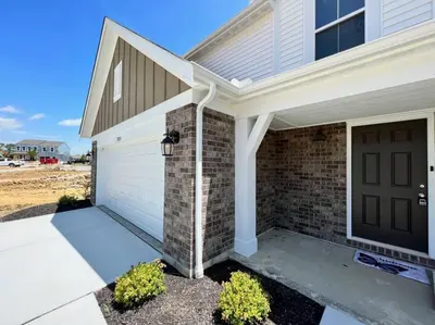 a house with a garage and a brown door at 7876 Ellington Court Cheerful 4 Bedroom Home Brand New Construction in Maineville