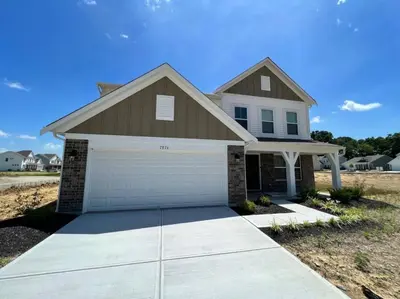 a house with a garage in front of it at 7876 Ellington Court Cheerful 4 Bedroom Home Brand New Construction in Maineville