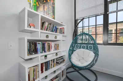 a room with a chair and bookshelves at 5103 Peters New Industrial Loft on Lebanon Bike Trail in Maineville