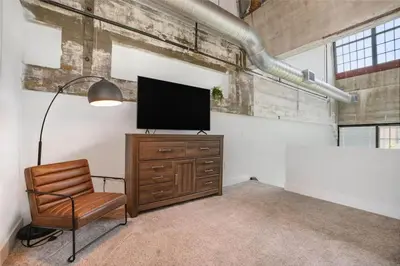 a living room with a television and a chair at 5103 Peters New Industrial Loft on Lebanon Bike Trail in Maineville