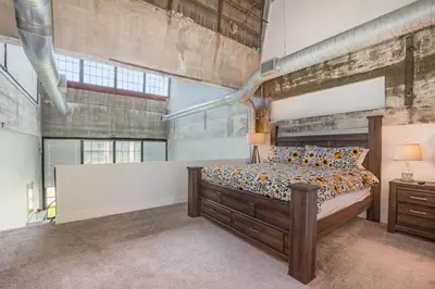 a bedroom with a large bed and a brick wall at 5103 Peters New Industrial Loft on Lebanon Bike Trail in Maineville