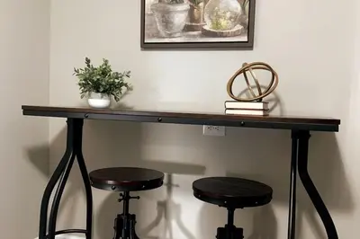 a table with two stools and a picture on the wall at 3311 Evanston Large Renovated 4 BDR Close to DTWN Laundry in Cincinnati