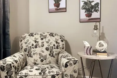 a living room with a chair and a table at 3311 Evanston Large Renovated 4 BDR Close to DTWN Laundry in Cincinnati