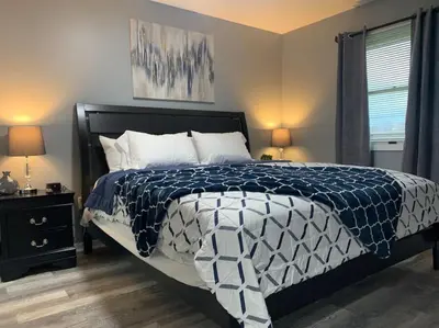 a bedroom with a bed with a blue and white comforter at 5145 Porsche Newly Remodeled 2 BDRM Ranch Attached Home in Rockdale