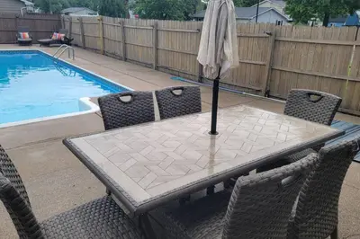 a table with an umbrella on it next to a pool at 1349 Jennings court Private Pool, Fire pit, BBQ A FUN place to RELAX in Mason