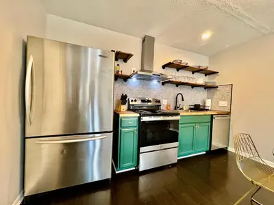a kitchen with a stainless steel refrigerator and green cabinets at 190 Overbrook Drive Swanky Swangos Dream Home by Jess in Monroe
