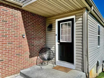 a chair sitting on a porch next to a door at 190 Overbrook Drive Swanky Swangos Dream Home by Jess in Monroe