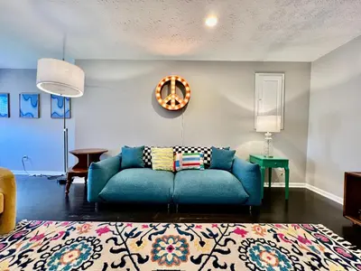 a living room with a blue couch and a rug at 190 Overbrook Drive Swanky Swangos Dream Home by Jess in Monroe