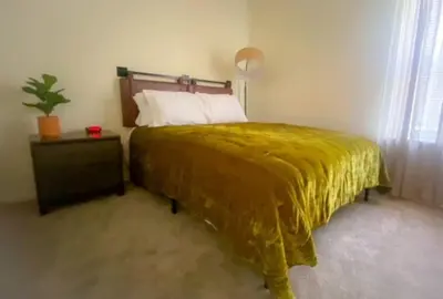 a bedroom with a bed with a yellow blanket on it at 240 Overbrook NEW Franks funky and fashionable furnished home in Monroe
