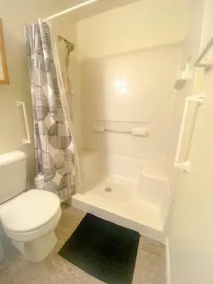 a white bathroom with a toilet and a shower at 240 Overbrook NEW Franks funky and fashionable furnished home in Monroe