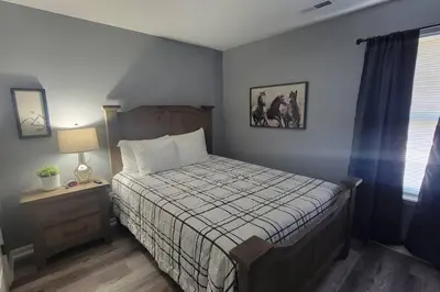 a bedroom with a bed and a table with a lamp at 160 Overbrook 3 bedroom home with privately fenced yard and hot tub in Monroe