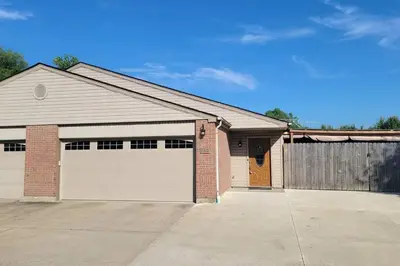 a house with two garage doors and a fence at 160 Overbrook 3 bedroom home with privately fenced yard and hot tub in Monroe
