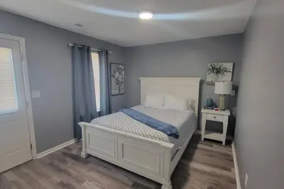 a bedroom with a white bed and a table at 160 Overbrook 3 bedroom home with privately fenced yard and hot tub in Monroe