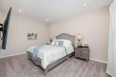 a white bedroom with a bed and a night stand at 1344 soaring way NEW Cheerful 5 bedroom home in quiet suburban area in Maineville