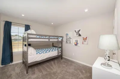 a bedroom with two bunk beds and a lamp at 1344 soaring way NEW Cheerful 5 bedroom home in quiet suburban area in Maineville