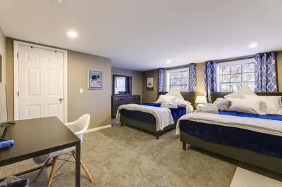 a bedroom with two beds and a desk in it at Cozy Newport Cottage Near Stadiums and Downtown in Newport