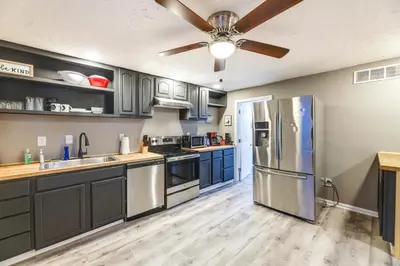 a kitchen with stainless steel appliances and blue cabinets at Cozy Newport Cottage Near Stadiums and Downtown in Newport