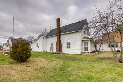 a white house with a brick chimney on a yard at Historic Alexandria Home with Private Yard! in Alexandria