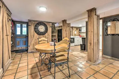 a kitchen with a table and a clock on the wall at Peaceful Mt Sterling Cabin Deck and Fire Pit! in Mount Sterling