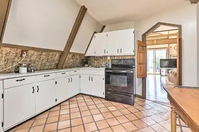 a kitchen with white cabinets and black appliances at Peaceful Mt Sterling Cabin Deck and Fire Pit! in Mount Sterling