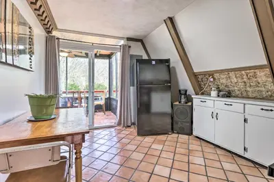 a kitchen with a refrigerator and a table at Peaceful Mt Sterling Cabin Deck and Fire Pit! in Mount Sterling