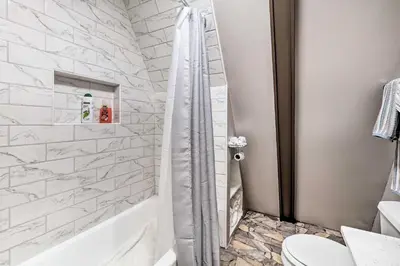 a bathroom with a shower with a toilet and a tub at Peaceful Mt Sterling Cabin Deck and Fire Pit! in Mount Sterling