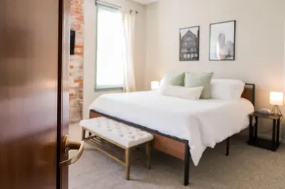 a bedroom with a large white bed and a window at The Penthouse- Heart of OTR w/Rooftop Terrace in Cincinnati