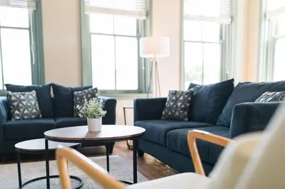 a living room with blue couches and a table at The Penthouse- Heart of OTR w/Rooftop Terrace in Cincinnati