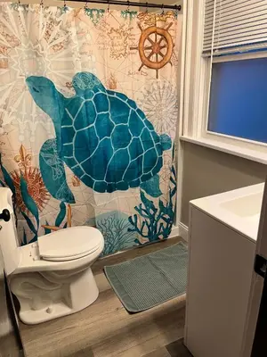 a bathroom with a turtle shower curtain and a toilet at Hunter #2 Private One Bed near Xavier & Downtown in Bellevue