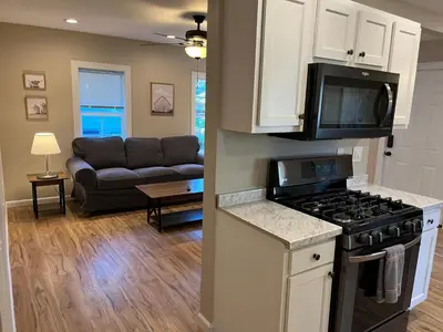 a kitchen and living room with a stove and a couch at Wilson Two Bedroom House in Historic Loveland in Loveland
