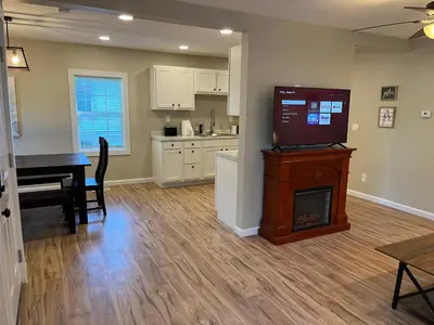 a living room with a fireplace and a kitchen with a table at Wilson Two Bedroom House in Historic Loveland in Loveland