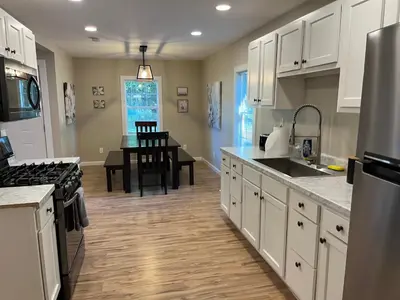 a kitchen with white cabinets and a dining room at Wilson Two Bedroom House in Historic Loveland in Loveland