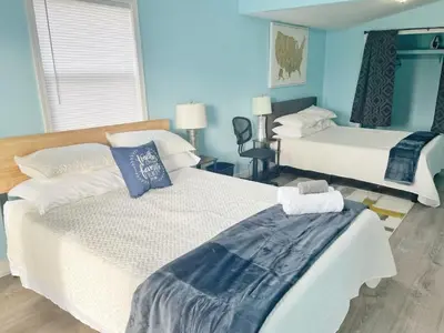 two beds in a room with blue walls at Housepitality - The Bliss Lodge - Large House in Columbus