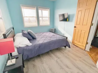 a bedroom with a purple bed and a television at Housepitality - The Bliss Lodge - Large House in Columbus