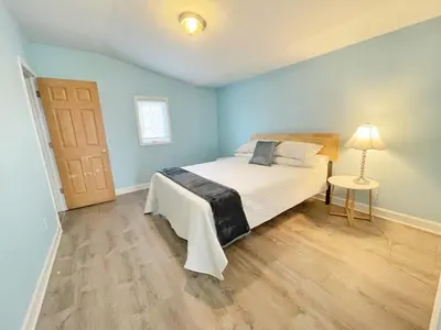 a bedroom with a bed and a table with a lamp at Housepitality - The Bliss Lodge - Large House in Columbus