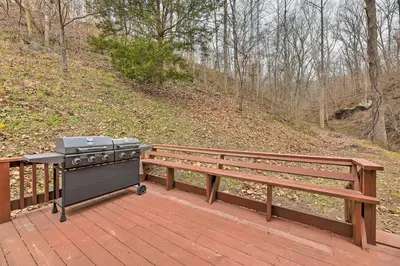a grill sitting on a deck next to a bench at Cozy Yatesville Lake Cabin Rental in Louisa! in Louisa
