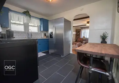 a kitchen with blue cabinets and a wooden table at WV Bohemian Bungalow in Kenova