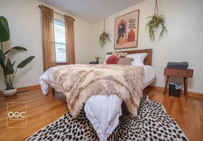 a bedroom with a large bed with a faux fur bedspread at WV Bohemian Bungalow in Kenova