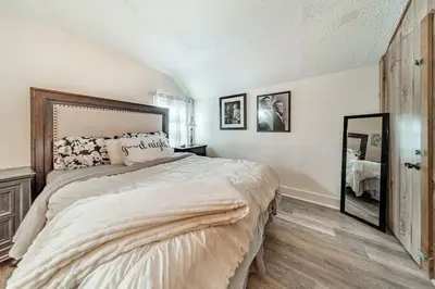a bedroom with a large bed and a mirror at Cottage in the Falls, 2 b, 2 bath, fireplace in Cuyahoga Falls