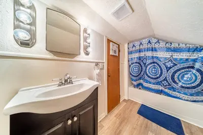 a bathroom with a sink and a shower curtain at Cottage in the Falls, 2 b, 2 bath, fireplace in Cuyahoga Falls