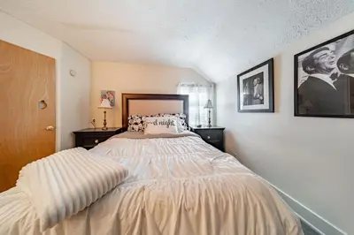 a bedroom with a bed and two pictures on the wall at Cottage in the Falls, 2 b, 2 bath, fireplace in Cuyahoga Falls