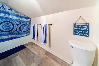 a bathroom with a toilet and a sign on the wall at Cottage in the Falls, 2 b, 2 bath, fireplace in Cuyahoga Falls