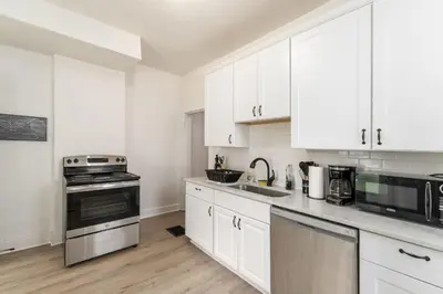 a kitchen with white cabinets and a stove top oven at Housepitality - The Madison House - Brand New in Columbus