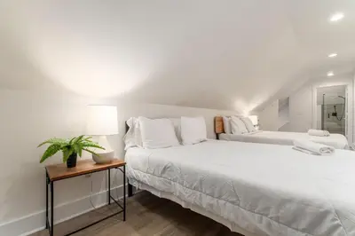 a white bedroom with a large bed and a table at Housepitality - The Madison House - Brand New in Columbus