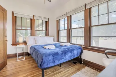 a bedroom with a bed in a room with windows at Updated 4BD House Near German Village w Parking in Columbus